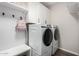 A laundry room with washer, dryer, storage cabinets, and a convenient bench at 18735 W San Juan Ave, Litchfield Park, AZ 85340