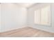 Neutral bedroom with wood flooring, white walls, and shuttered window at 20453 N 95Th Pl, Scottsdale, AZ 85255