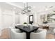 Elegant dining room featuring a modern chandelier, stylish seating, and access to the living area at 20453 N 95Th Pl, Scottsdale, AZ 85255