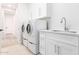 Bright laundry room with white washer and dryer, and white cabinets at 20453 N 95Th Pl, Scottsdale, AZ 85255