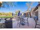 Outdoor patio area with tables, chairs, umbrellas, string lights, and lush landscaping at 20453 N 95Th Pl, Scottsdale, AZ 85255