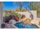 Beautiful pool with waterfall feature, accented by desert-themed metal art and desert foliage at 20453 N 95Th Pl, Scottsdale, AZ 85255