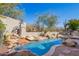 Resort-style pool area with waterfall feature, lush landscaping, and desert views at 20453 N 95Th Pl, Scottsdale, AZ 85255