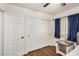 Bedroom featuring blue curtains, wood-look floors and ceiling fan at 21941 W Solano Dr, Buckeye, AZ 85326