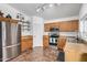 Cozy kitchen featuring tile flooring, stainless steel appliances, and wooden cabinets at 21941 W Solano Dr, Buckeye, AZ 85326