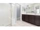 Bathroom with double vanity, framed mirror, and walk-in shower with white tile surround at 23740 W Hilton St, Buckeye, AZ 85326