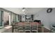 Well-lit dining area with seating for six, adjacent to a living room with sliding glass doors at 29031 N 125Th Ln, Peoria, AZ 85383