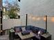 Cozy patio featuring cushioned seating, stylish pillows, and a modern fire pit, illuminated by charming string lights at 29031 N 125Th Ln, Peoria, AZ 85383