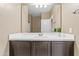 Bathroom vanity features a white countertop, dark brown cabinets, and large mirror at 30382 W Vale Dr, Buckeye, AZ 85396