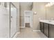 Modern bathroom features a glass shower, a vanity with a white top, and an open closet at 30382 W Vale Dr, Buckeye, AZ 85396