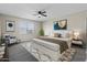 Bright bedroom showcases a large window, ceiling fan, accent chair, and stylish artwork at 30382 W Vale Dr, Buckeye, AZ 85396