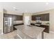 Well-equipped kitchen featuring dark cabinets, stainless steel appliances, a center island, and tile flooring at 30382 W Vale Dr, Buckeye, AZ 85396
