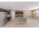 Modern kitchen with dark cabinetry, stainless steel appliances, granite countertops and tile flooring at 30382 W Vale Dr, Buckeye, AZ 85396
