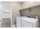 Bright laundry room features white appliances and convenient shelving at 30382 W Vale Dr, Buckeye, AZ 85396