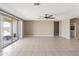 Expansive living room with tiled floors, neutral paint, ceiling fan and sliding glass doors to backyard patio at 30382 W Vale Dr, Buckeye, AZ 85396