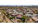 Panoramic aerial view of a desert community with red-tiled roofs, landscaped yards, and an outdoor fire pit area at 31525 N Gold Field Rd, San Tan Valley, AZ 85143