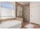 Bathroom featuring a glass-enclosed shower and a soaking tub, next to a bright window at 31525 N Gold Field Rd, San Tan Valley, AZ 85143