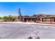 Exterior view of the community clubhouse with an American flag and ample parking at 31525 N Gold Field Rd, San Tan Valley, AZ 85143