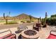 Paver patio with fire pit, comfortable seating, golf course and desert mountain views at 31525 N Gold Field Rd, San Tan Valley, AZ 85143