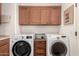 Laundry room with side-by-side washer and dryer, and overhead storage cabinets at 31525 N Gold Field Rd, San Tan Valley, AZ 85143