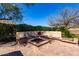 Outdoor living space with built-in seating, a fire pit, desert landscaping, and paver patio at 31525 N Gold Field Rd, San Tan Valley, AZ 85143