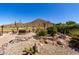 Backyard with rock water feature, desert landscaping, paver patio, and mountain views at 31525 N Gold Field Rd, San Tan Valley, AZ 85143