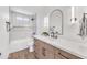 Modern bathroom showcasing a sleek vanity with a bright white countertop and updated tile in the shower at 3517 E Hartford Ave, Phoenix, AZ 85032