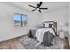 Cozy bedroom with ceiling fan, a patterned rug, and a large window for natural light at 3517 E Hartford Ave, Phoenix, AZ 85032