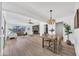 Open floor plan seamlessly integrates living room, stone fireplace, and dining area with stylish chandelier at 3517 E Hartford Ave, Phoenix, AZ 85032
