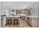 Modern kitchen with an island, seating, stainless steel appliances, and light wood cabinets at 3517 E Hartford Ave, Phoenix, AZ 85032