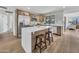 Bright kitchen featuring an island with seating, stainless steel refrigerator, and wood-look flooring at 3517 E Hartford Ave, Phoenix, AZ 85032