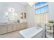 Chic bathroom featuring a soaking tub, designer lighting, and double sink vanity at 4037 E Minton Cir, Mesa, AZ 85215