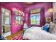 Vibrant bedroom featuring a bright pink wall and bathroom with tiled floor and light wood vanity at 4037 E Minton Cir, Mesa, AZ 85215