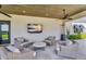 Comfortable covered patio featuring wicker seating, ceiling fan and a large screen TV at 4037 E Minton Cir, Mesa, AZ 85215