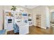 Well-lit home office featuring custom shelving, a desk, and warm wood flooring at 4037 E Minton Cir, Mesa, AZ 85215