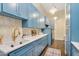 Bright laundry room features blue cabinets, a stainless sink and modern pendant lights at 4037 E Minton Cir, Mesa, AZ 85215