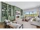 Bright living room with fireplace, built-in shelving, and large windows overlooking the backyard at 4037 E Minton Cir, Mesa, AZ 85215