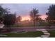 Evening shot of community green space bordered by a fence and walking path, framed by a residential backyard at 4638 S San Benito Ct, Gilbert, AZ 85297
