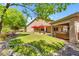 Lush backyard featuring a well-maintained lawn, covered patio, hot tub, and mature trees for shade at 4638 S San Benito Ct, Gilbert, AZ 85297