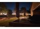 Backyard kitchen area featuring a built-in sink, grill, and shaded patio, illuminated by ambient lighting at 4638 S San Benito Ct, Gilbert, AZ 85297