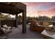 Covered patio with wicker furniture, ceiling fan and outdoor kitchen with pizza oven at 470 N 168Th Ln, Goodyear, AZ 85338