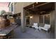 Covered patio with wicker furniture, ceiling fan and outdoor kitchen with pizza oven at 470 N 168Th Ln, Goodyear, AZ 85338