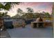 Outdoor kitchen area featuring a pizza oven, fire pit, and hammock for relaxation and entertaining at 470 N 168Th Ln, Goodyear, AZ 85338