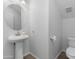 Minimalist powder room with a white pedestal sink and toilet at 470 N 168Th Ln, Goodyear, AZ 85338