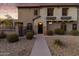 A cozy two-story home with a stone facade, wrought iron gate, and a well-maintained front yard at 470 N 168Th Ln, Goodyear, AZ 85338