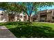 An exterior view of an apartment complex nestled within a green lawn and lush trees on a beautiful day at 520 N Stapley Dr # 286, Mesa, AZ 85203