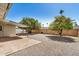 Back patio with awning, tile, desert landscaping, and privacy fence at 5865 E Anaheim St, Mesa, AZ 85205