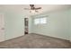 Neutral bedroom with large window, carpet, and ceiling fan at 5865 E Anaheim St, Mesa, AZ 85205