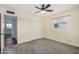 Bedroom featuring carpet, ceiling fan, and view of other room through doorway at 5865 E Anaheim St, Mesa, AZ 85205