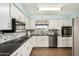 Charming kitchen with white cabinets, stainless steel appliances, and stylish backsplash at 5865 E Anaheim St, Mesa, AZ 85205